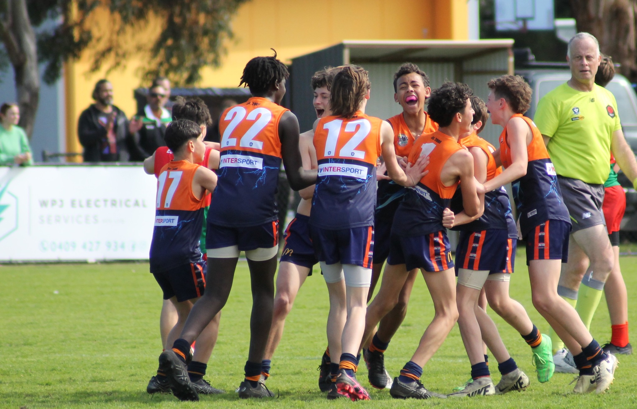 Group of teenage footballers celebrating joyfully after winning a game